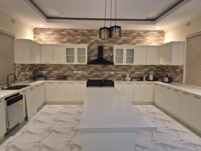 Stain-Resistant Cream-White Kitchen Cabinets with Pull-Out Drawers and Brick Accents Cut Clutter for Busy Family Cooking