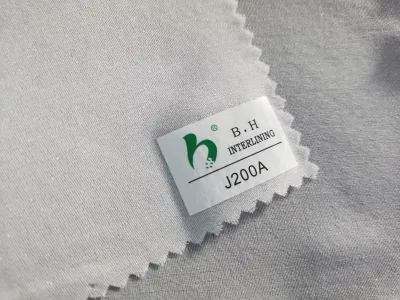 Wholesale 20D Water-jet WOVEN FUSIBLE INTERLINING 100% Polyester Elastic Voile Fabric PA Coated Embroidered Roll in China